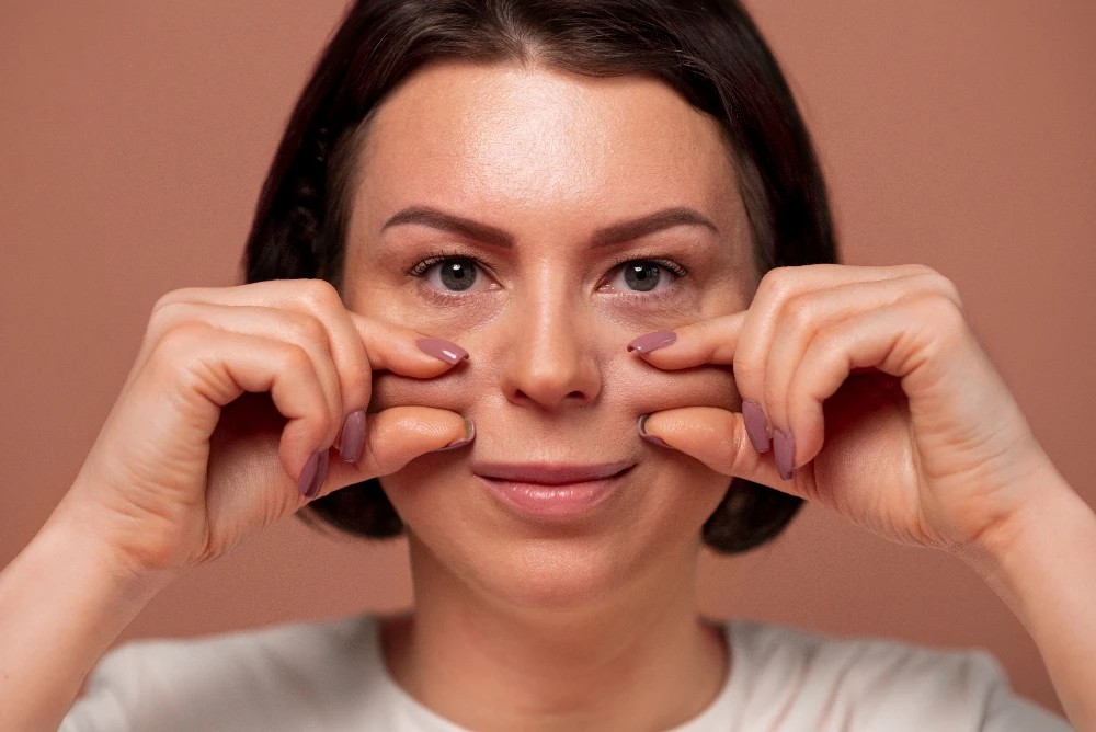 Femme effectuant un massage facial pour réduire les cernes sous les yeux.