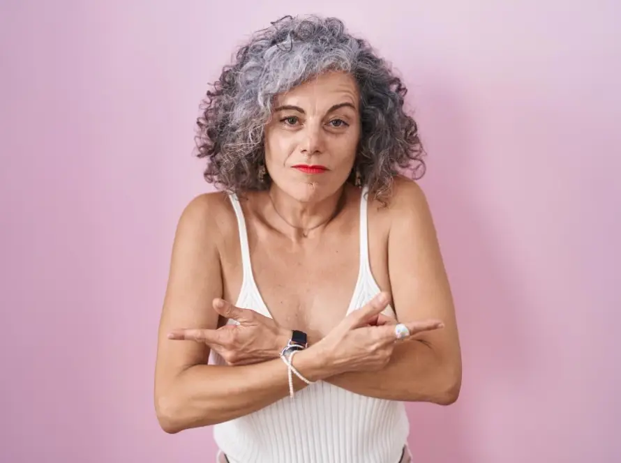 femme de cinquante cachant sa poitrine par complexe
